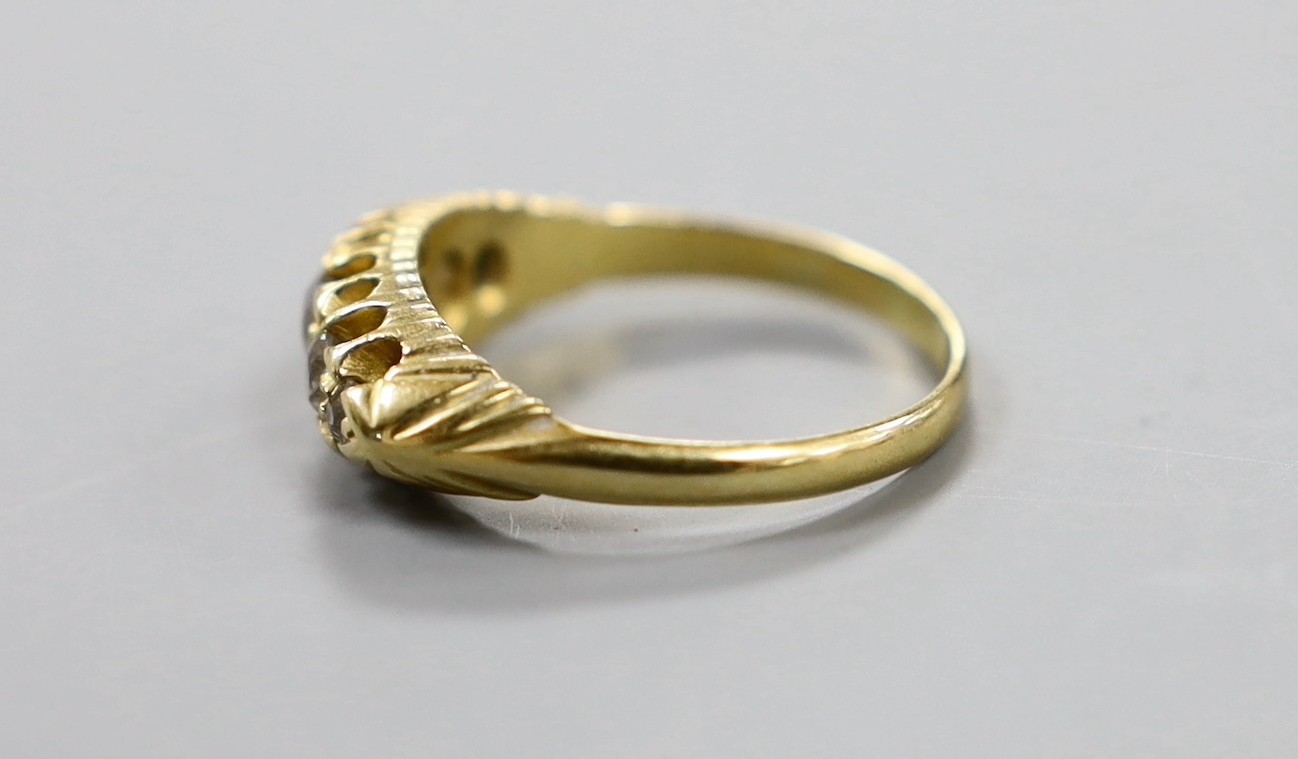 An Edwardian 18ct gold and graduated five stone diamond set half hoop ring, size P, gross weight 4.9 grams.